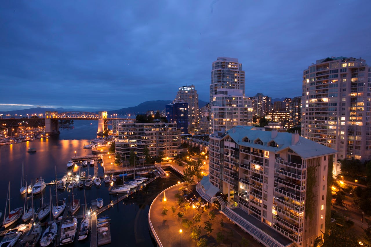 Stunning nighttime view of Vancouver's marina, skyscrapers, and lit-up Burrard Bridge.