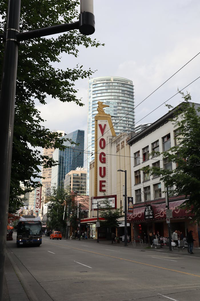 Urban street scene featuring the iconic Vogue sign in Vancouver's bustling cityscape.