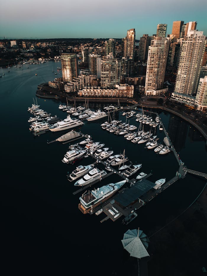 Captivating aerial view of Vancouver skyline with marina and yachts, showcasing urban architecture and coastal beauty.