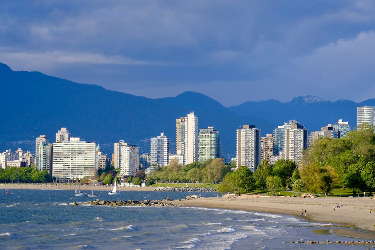 gallery-1 Vancouver's skyline from the beach with water and mountains in view.