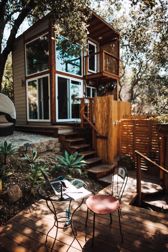 A tranquil outdoor workspace in Topanga, featuring a laptop, chairs, and lush greenery.